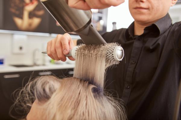 Woman getting her hair blown out at salon.