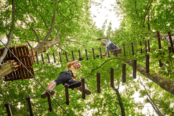 Two people on ropes course ladders.