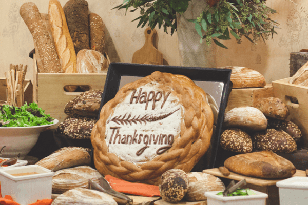 Table assortment of breads with &quot;Happy Thankgiving&quot; bread as a centerpiece