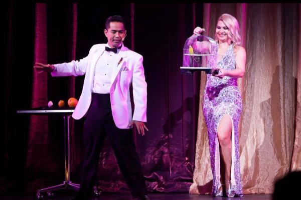 Anthony Salazar on stage with woman doing magic.