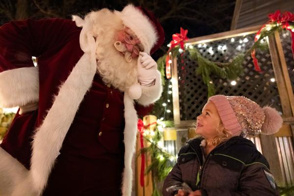 Santa looking down at little girl.