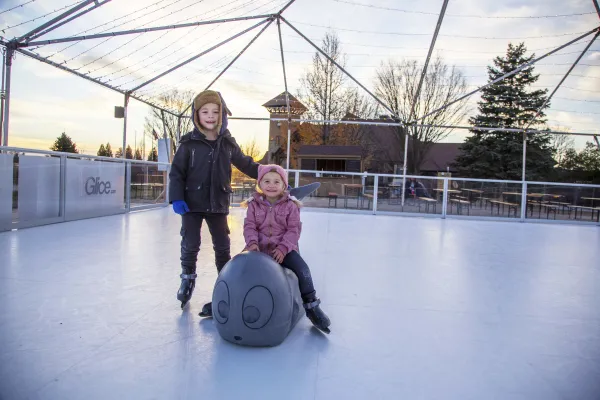 Two children glice skating.