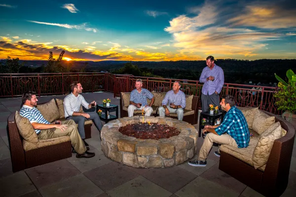 Group of guys sitting by a fire pit on the Fire and Water Terrace