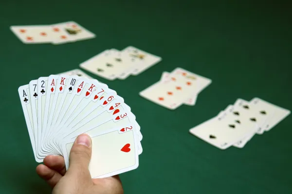 Hand holding spread out playing cards.