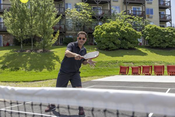 Man holding pickleball paddle.