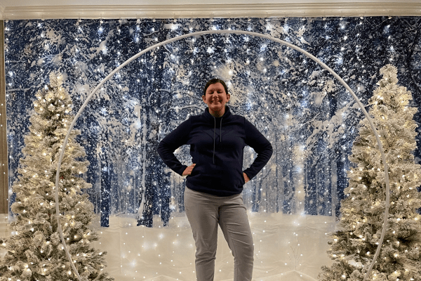 Woman stands in snow globe for photo.