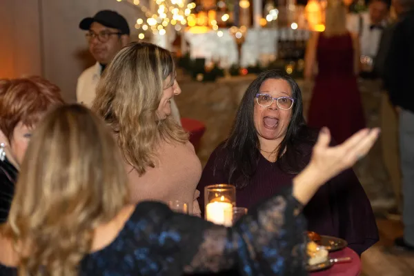 Friends standing around table at holiday party.