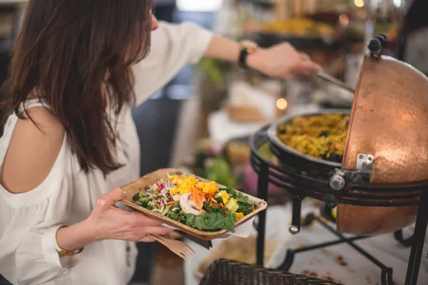 Woman scooping rice onto her plate during buffet.