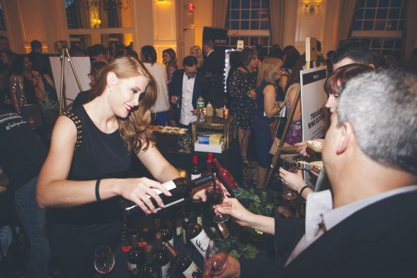 Woman pouring wine into glass at NJ Wine &amp; Food Festival.