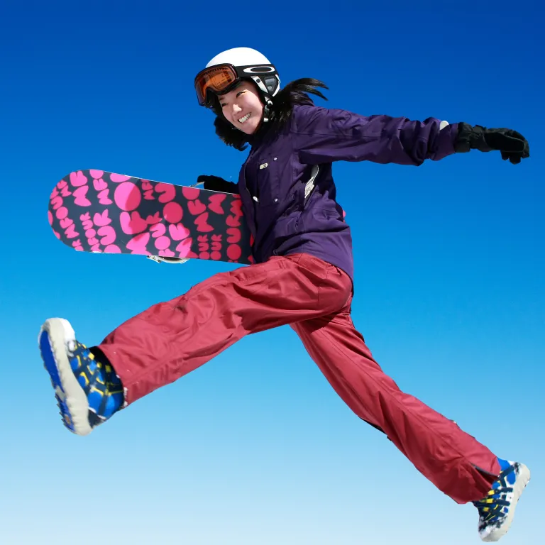 Snowboarder jumping against clear blue sky. 