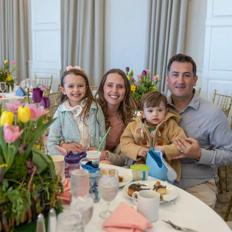 Family of four sitting at table in Emerald Ballroom for Mother's Day.