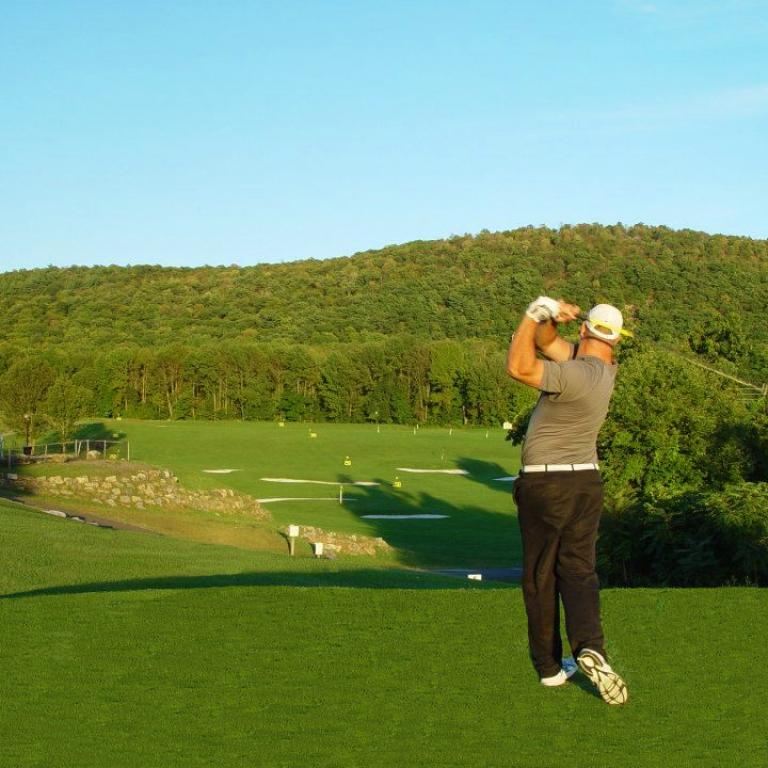 Golfer practicing at the driving range at Black Bear Golf Course