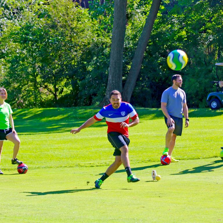 Friends playing a round of foot golf at a resort close to NYC