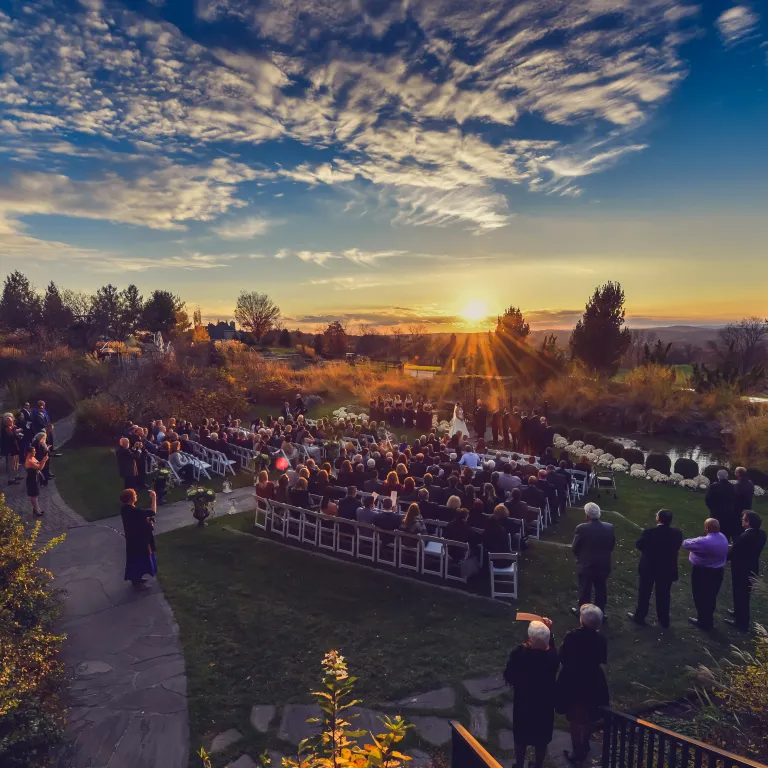 Sun setting on outdoor wedding ceremony at Grand Cascades Lodge.