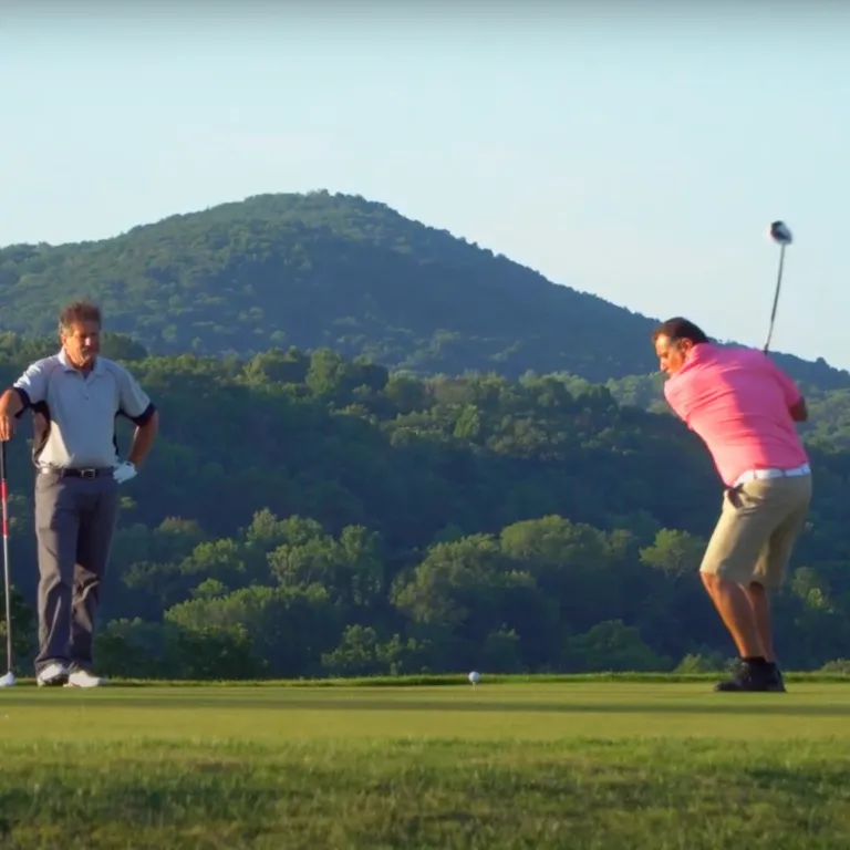 Two Golfers making their swings at a golf course near NYC