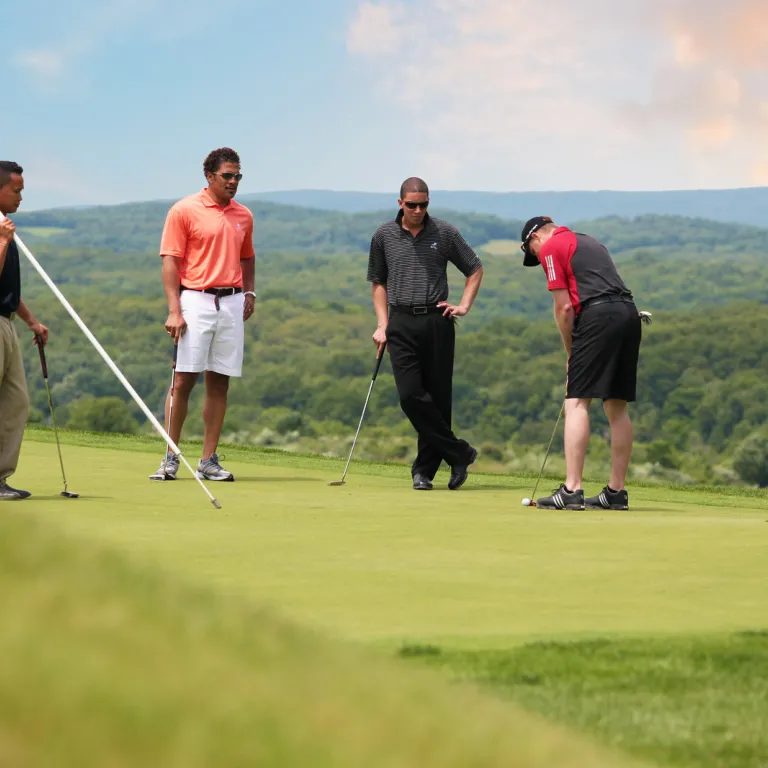 Foursome on the putting green at Wild Turkey golf course