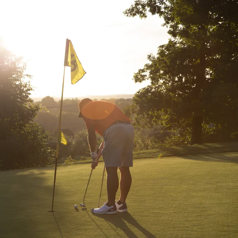 Man making his putt at a hole on Black Bear Golf Course