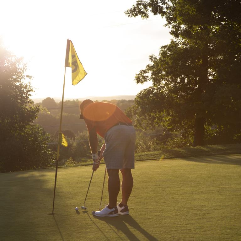 Man making his putt at a hole on Black Bear Golf Course