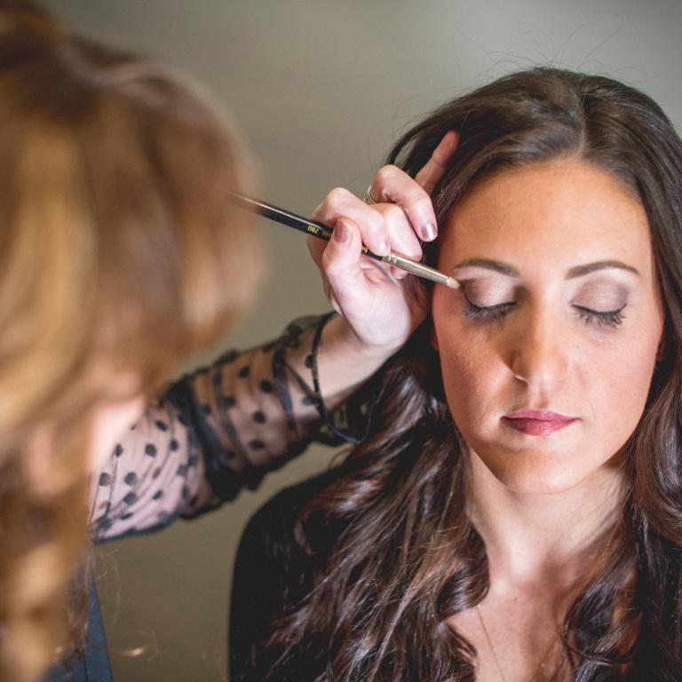 Woman getting her eye makeup done.