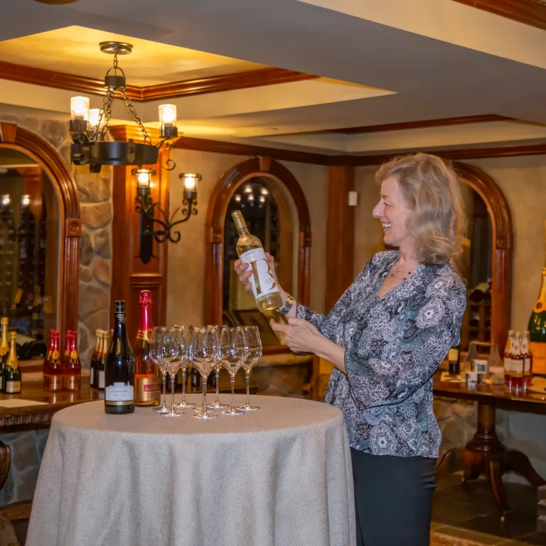 Susanne Wagner holding a bottle of wine in the wine cellar.