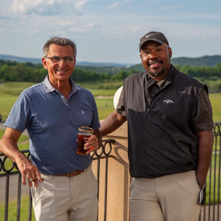 Two guys on the outdoor patio of a golf club at Crystal Springs Resort