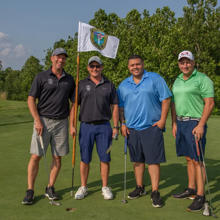 Four guys standing with a law enforcement golf flag at Ballyowen Golf course