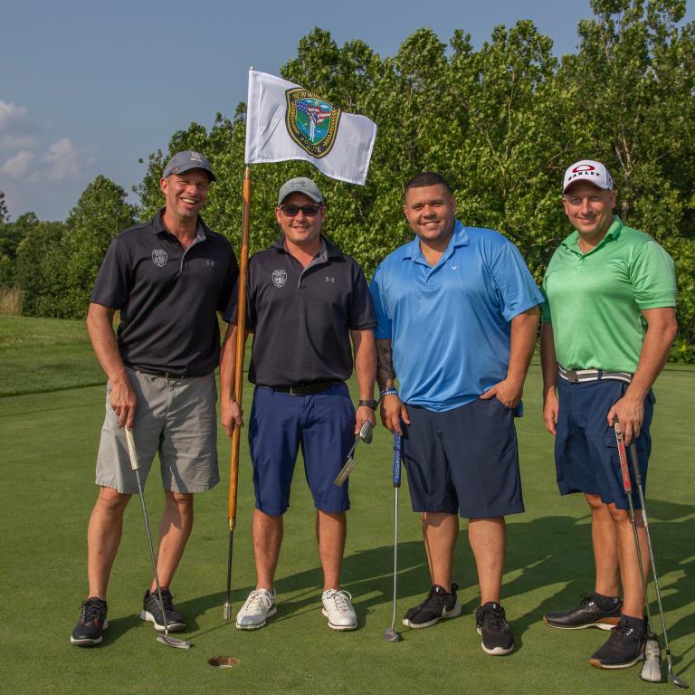 Four guys standing with a law enforcement golf flag at Ballyowen Golf course