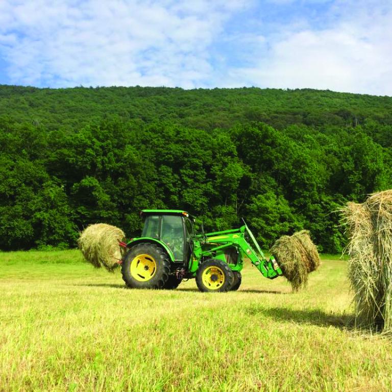 Tractor picking up hay