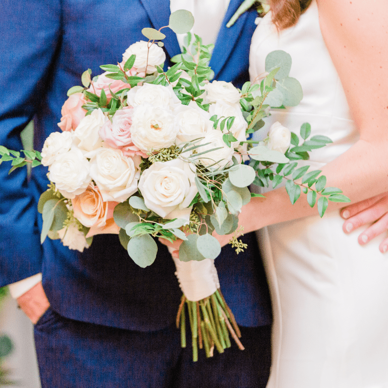 Bride and groom holding flower bouquet