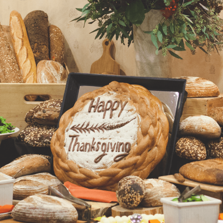 Table assortment of breads with &quot;Happy Thankgiving&quot; bread as a centerpiece