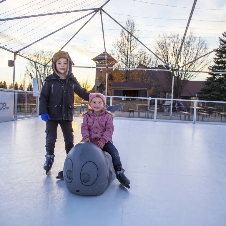 Two children glice skating.