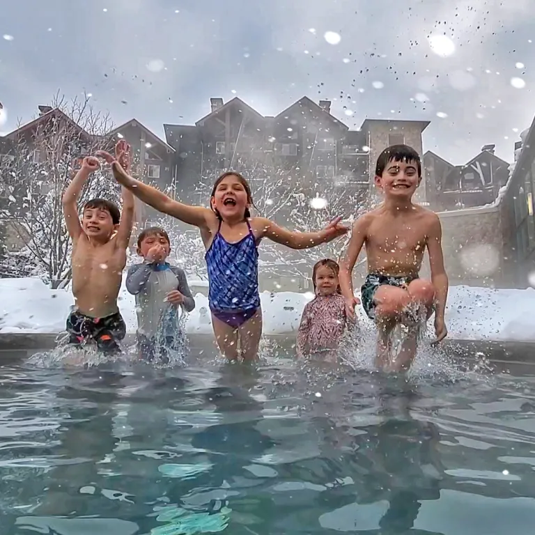 Kids jumping into snow pool at Grand Cascades Lodge 