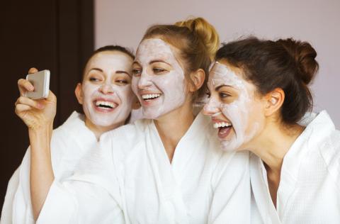 Woman with face masks on taking a selfie.