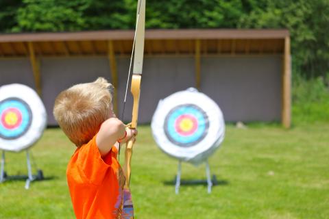 Boy doing archery target practice 