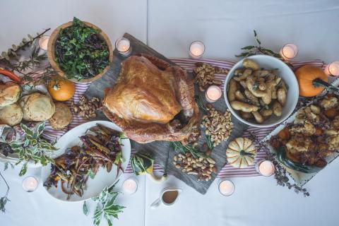 Table with spread of Thanksgiving food and candles 