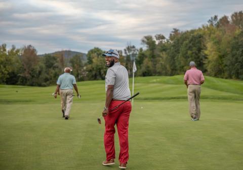 Golfers walking on a golf course.