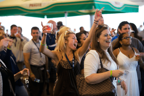 Woman with beer tasting in her hand singing at NJ Beer and Food Festival.