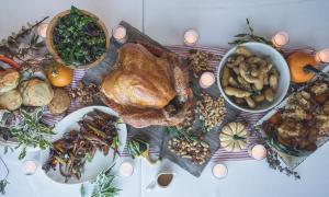 Table with spread of Thanksgiving food and candles 