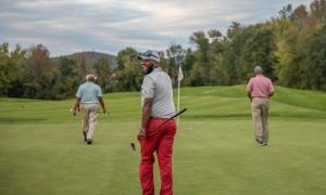 Golfers walking on a golf course.