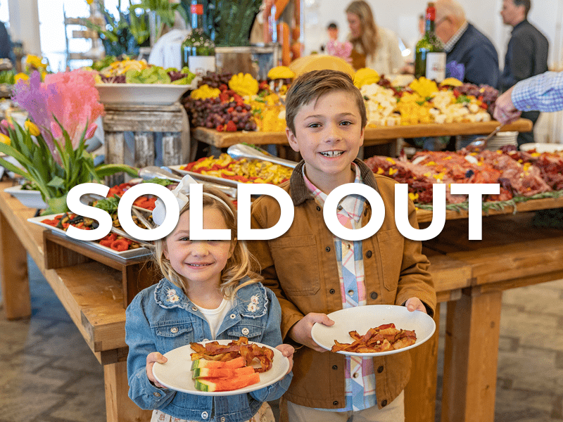 Two children holding plates of food during Easter brunch with SOLD OUT sticker overlayed.