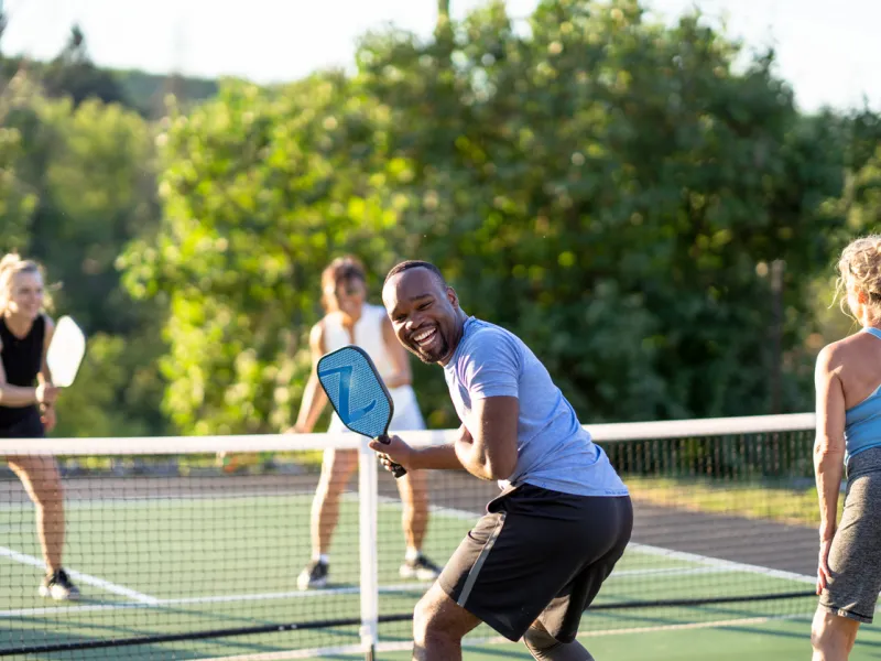 Four people playing pickleball