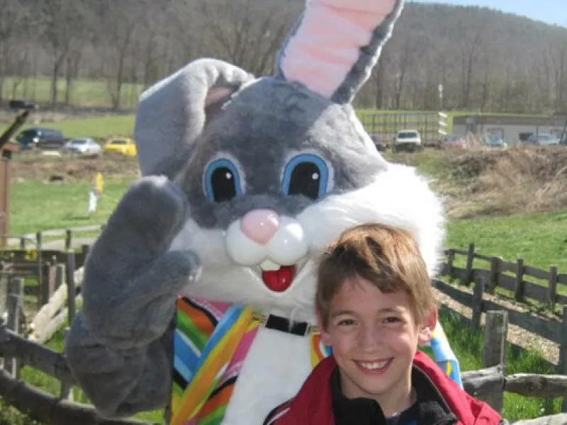 Child standing with Easter Bunny at Heaven Hill Farm. 