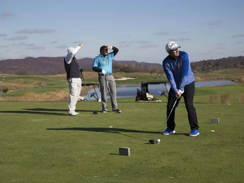 Three guys teeing off at a golf course at a resort in New Jersey