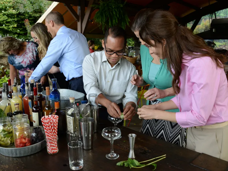 Group of coworkers taking part in a mixology teambuilding glass.