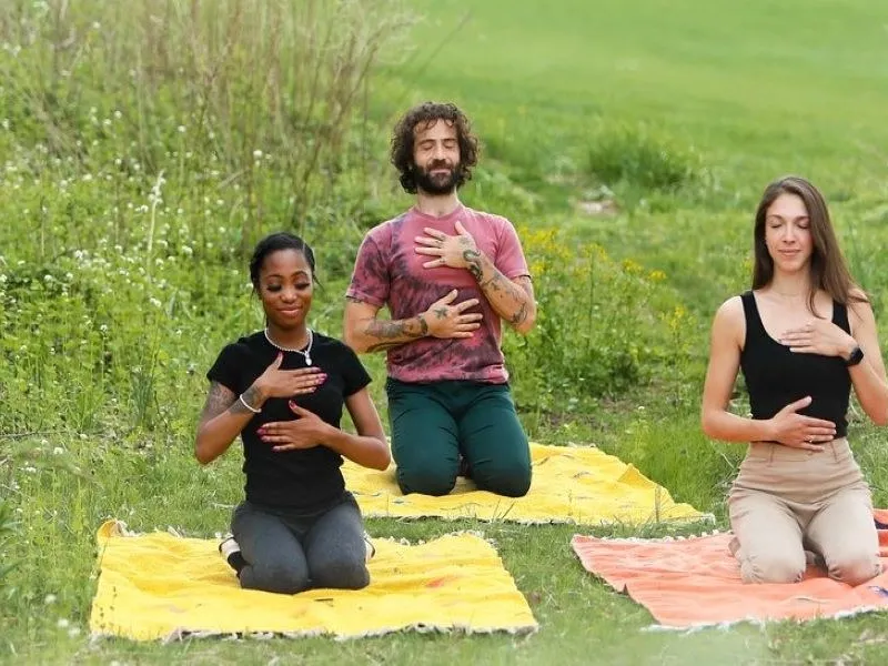 Group of three people meditating in a field  in New Jersey. 