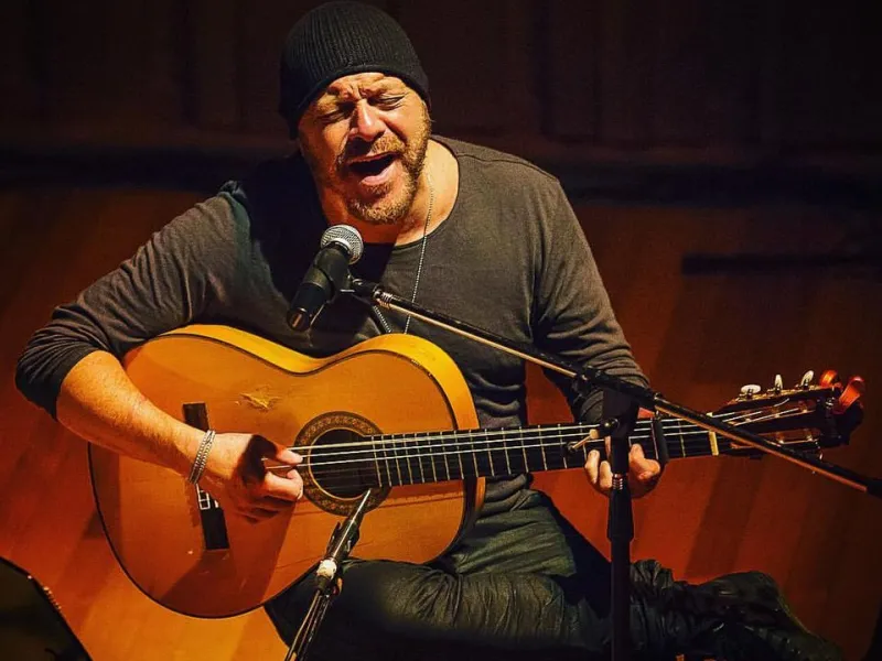 Hernan Romero playing guitar on stage.