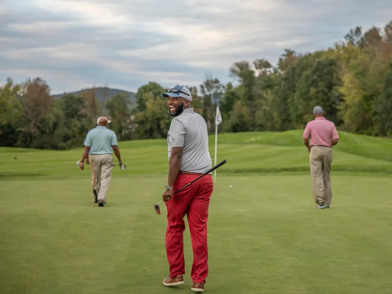 Golfers walking on a golf course.