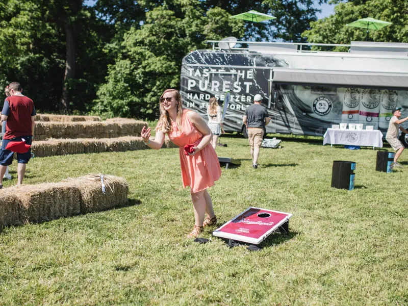 Women tossing bag playing corn hole at NJ Beer &amp; Food Festival