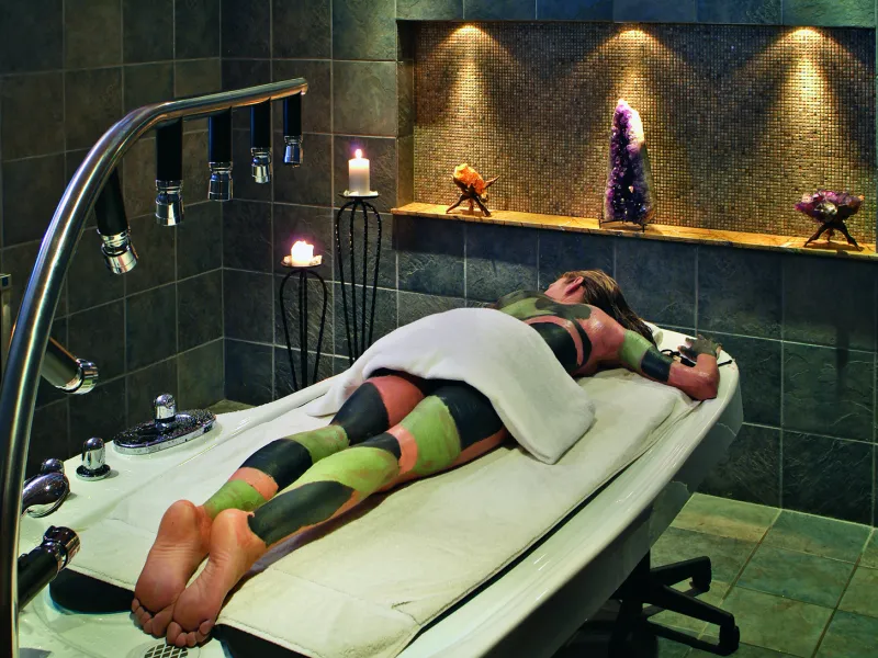 Woman receiving mud body treatment at Elements Spa.