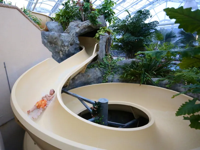 Young boy riding down water slide at Biosphere Pool